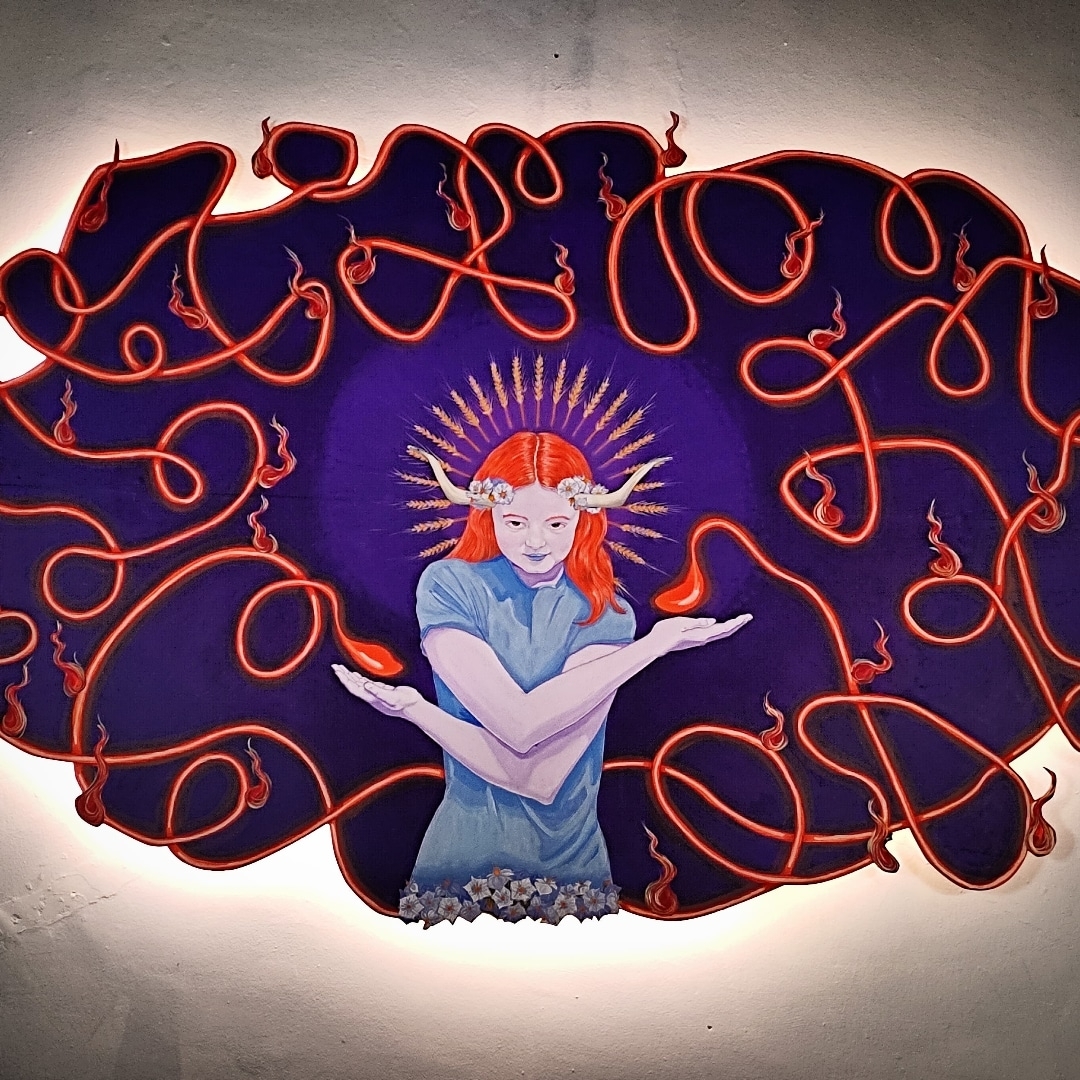Mural iluminado de una figura rodeada por hilos rojos