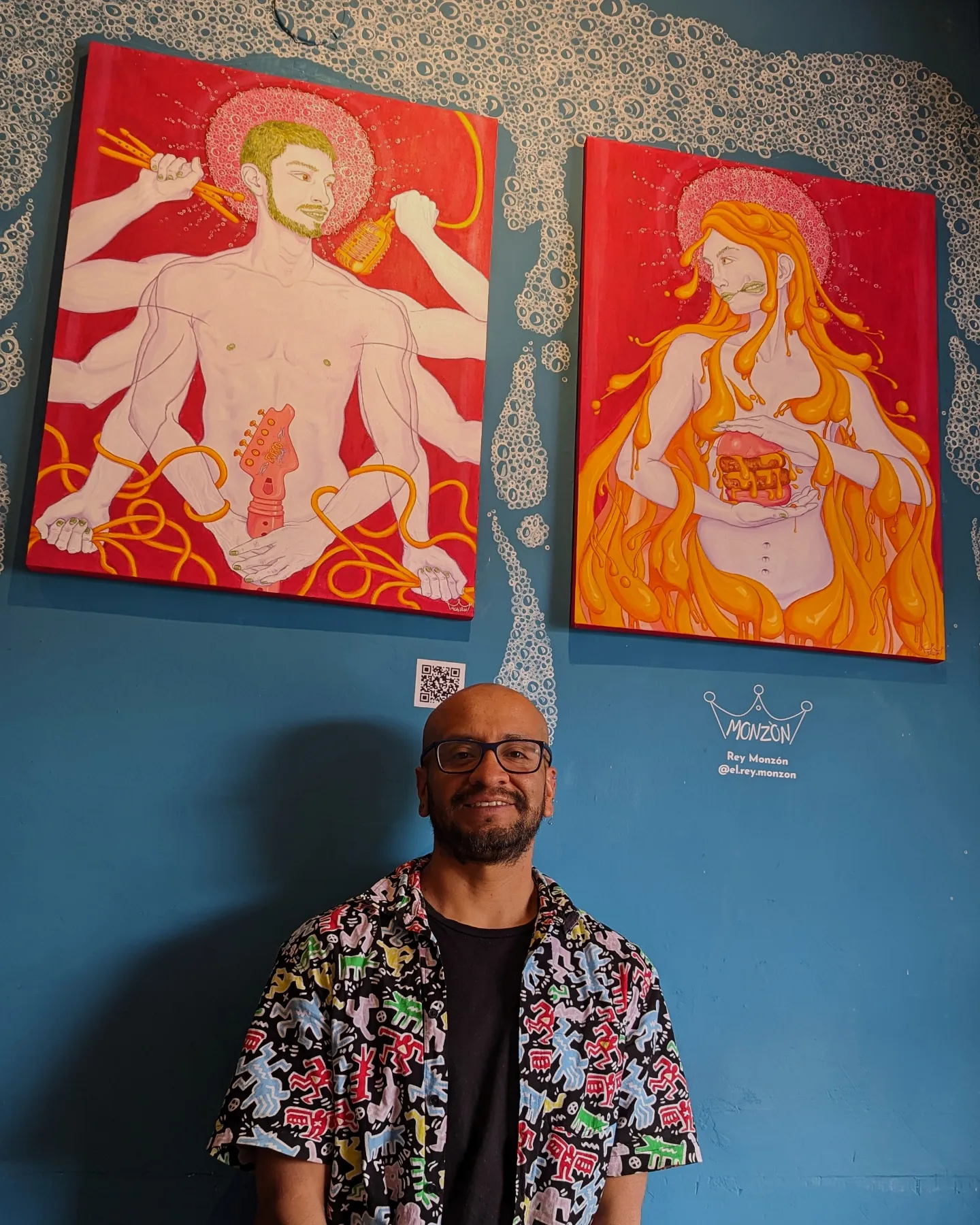 Reynaldo Monzón frente a dos de sus obras